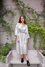 Load image into Gallery viewer, Beautiful brunette Russian model wearing silk satin kimono dress called Anatolé in silver color. Front view image. Nynolia brand.
