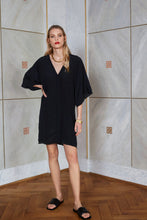 Load image into Gallery viewer, Blonde model wearing slow fashion silk kaftan dress Milo in black color front view