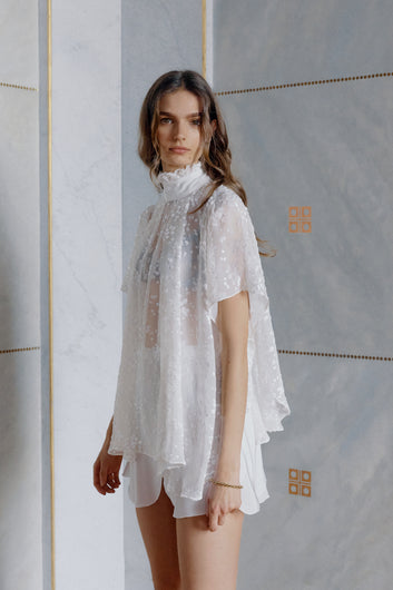 Blonde model wearing transparent silk dress Papillon in white