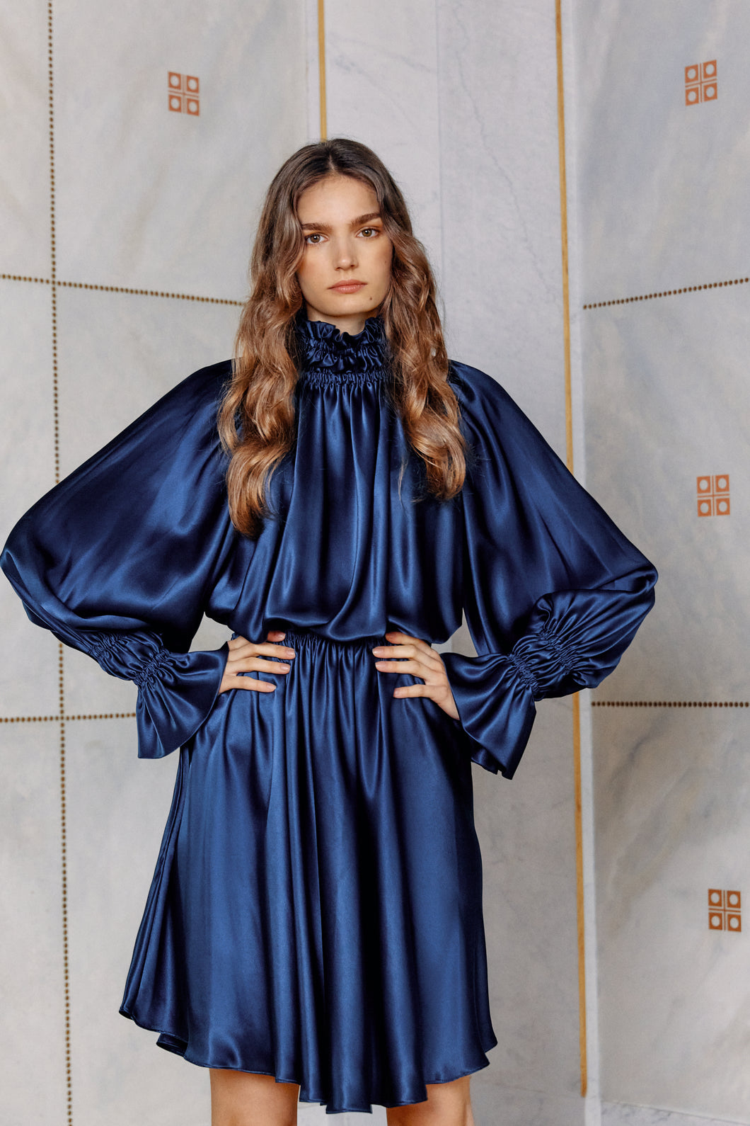 Brunette model wearing satin silk dress Kali in dark blue close up front view